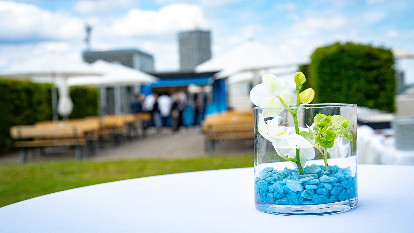 Tischdekoration mit weißer Orchidee und blauen Steinen beim Outdoor-Networking